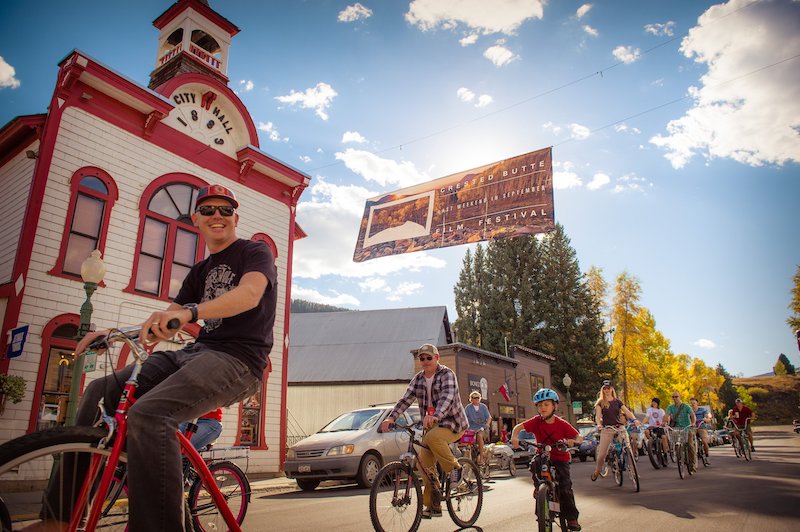 A family rides in a bike parade at the Creste Butte Film Festival