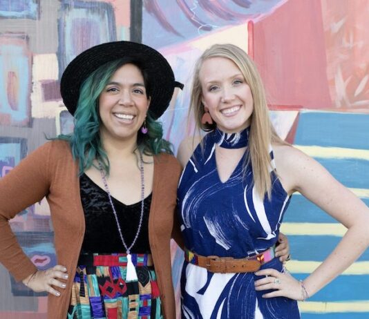 Where to Thrift in Colorado Springs two women stand in front of colorful mural in vintage clothing.
