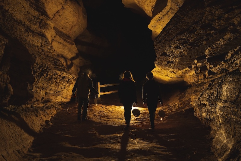 Silhouettes descend into Cave of the Winds for a haunted lantern tour at Halloween in Colorado Springs