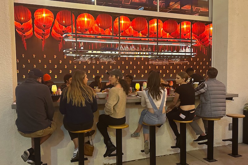 View from the outdoor patio bar looking inside Night Ramen in Colorado Springs.