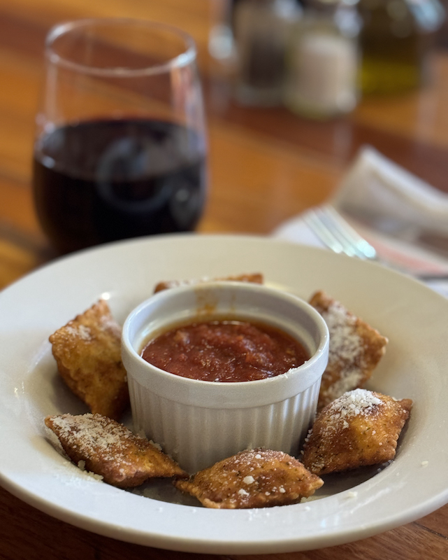 Ravioli and red wine at Red Gravy, one of the best restaurants for happy hour in Colorado Springs