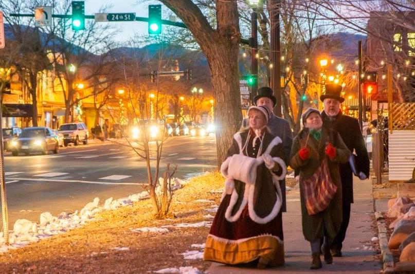 Dickens Carolers walk the sidewalk and sing in Old Colorado City during the holiday shopping season.