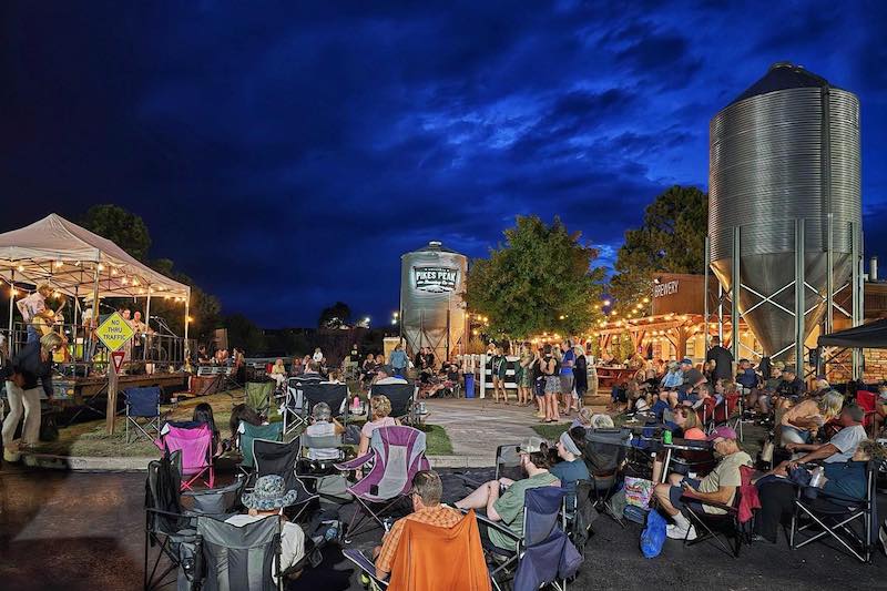 A night time concert among the brewing tanks and string lights at the Pikes Peak Brewing Company beer garden in Monument, Colorado.