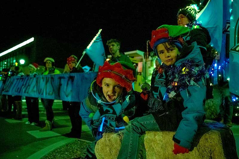 Two kids at the Festival of Lights Parade, one of the best things to do in Colorado Springs this weekend.