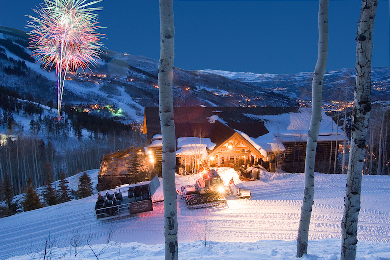 A sleigh is parked in front of Allie's Cabin at Beaver Creek with fireworks colorfully lighting up the sky above Beaver Creek ski resort. The site is part of the Alpine Table events, where James Beard Award winning chefs collaborate with Beaver Creek's cabin restaurants.