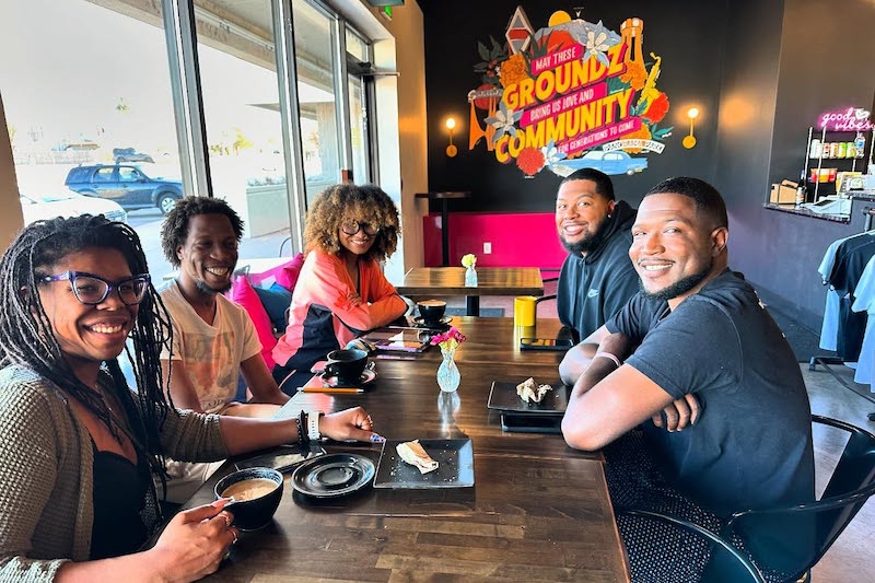 Black community leaders gathered around a table at Stompin' Groundz