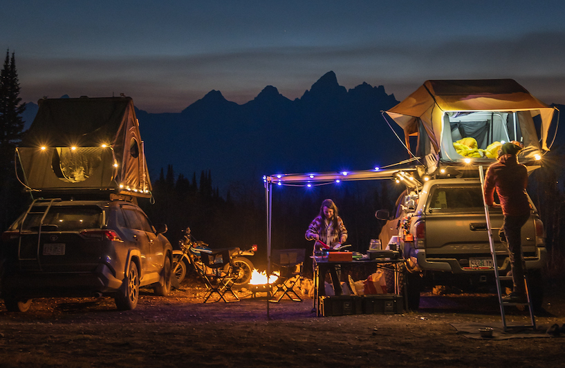 A campsite in the Tetons with Luci string lights strung between cartop tents.
