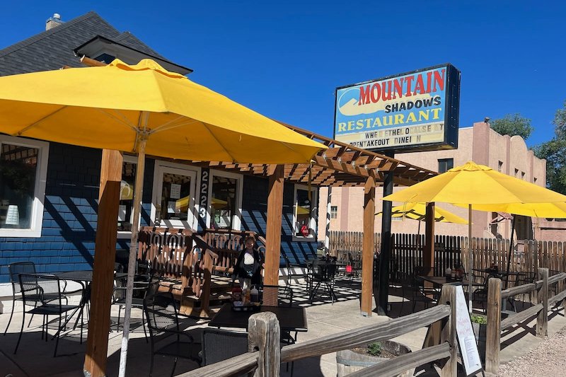 Yellow umbrellas on the patio of Mountain Shadows. The restaurant closed permanently in 2024.