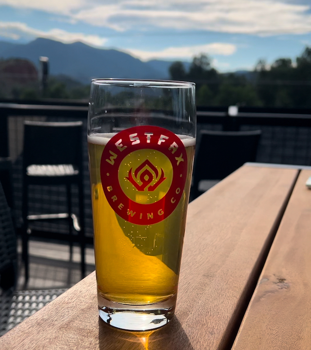 A glass of beer with Pikes Peak in the background at WestFax Springs, a new brewery in Colorado Springs in 2024