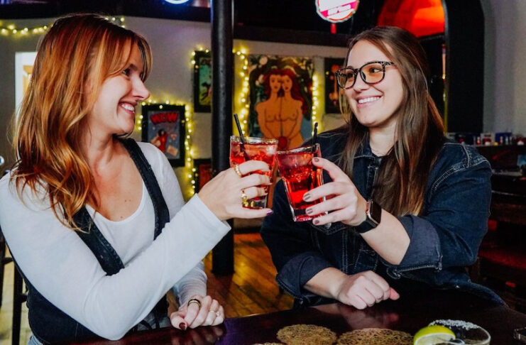 Two women cheers glasses at Mother Muffs, one of our picks for Galentine's Day karaoke