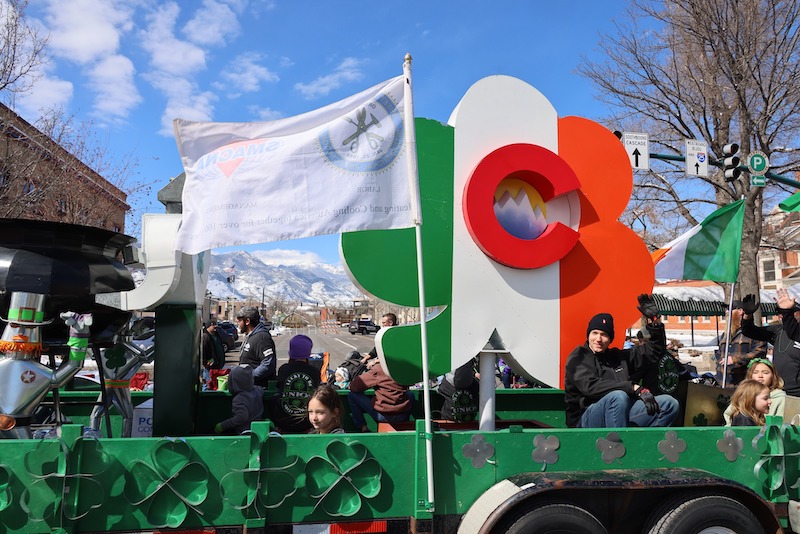 A float with Irish colored shamrock rolls through downtown at the St. Patrick's Day Parade, one of the best things to do in Colorado Springs this weekend.
