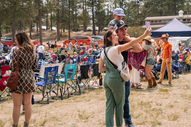 A couple takes a selfie with a toddler on dad's shoulders at the MeadowGrass Music Festival in Colorado Springs. 