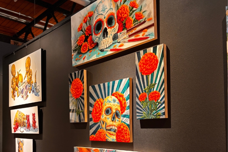 Paintings hang on wall in the Look Up Gallery.