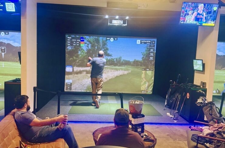 Golfers play and hang out in an indoor golf simulator lounge at City Golf COS at Trainwreck.