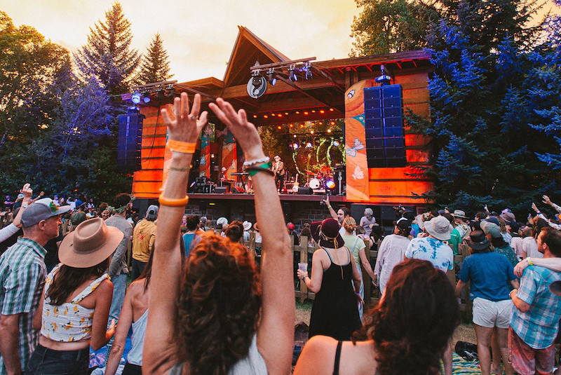 A crowd cheers for the band on stage at RockyGrass, one of the best Colorado music festivals.