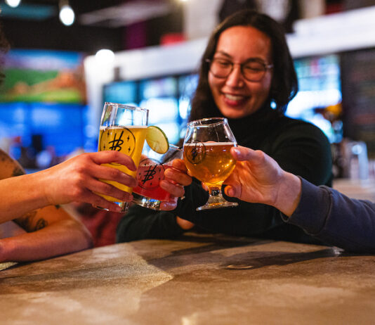 Crafts & Drafts Passport Levels Up 10 Years of Drink Deals Friends cheers with beer glasses at Voodoo Brewing, enjoying cheap drinks with the Crafts and Drafts Passport in Colorado Springs.