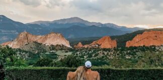 A couple sits beside the infinity pool, looking at Garden of the Gods and Pikes Peak. It's this view that makes Garden of the Gods Resort one of the best hotels in Colorado Springs.