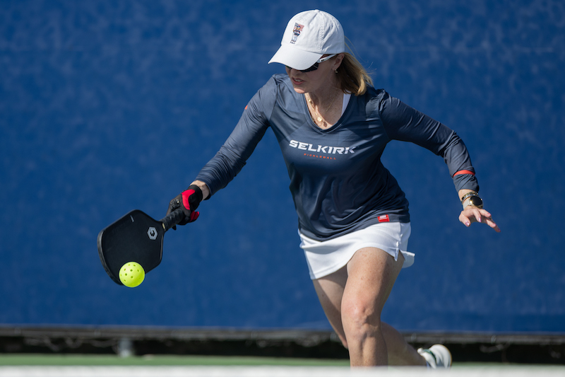 A woman hits the ball in a pickleball match at a Golden Ticket tournament. 