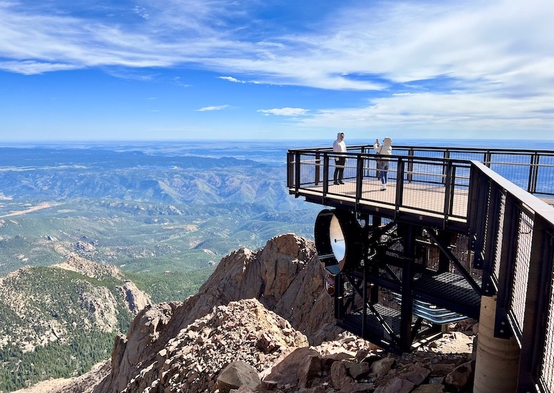 Visitors take a photo on an observation deck at the summit of Pikes Peak