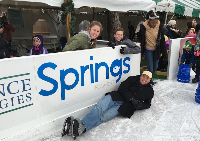 John Sawyer lays on the rink in front of the Springs magazine banner at Skate in the Park in downtown Colorado Springs.