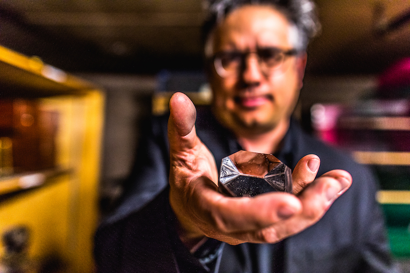 Colorado College professer Steven Hayward holds prism from a long lost telescope on his quest to find the artifact ahead of the full solar eclipse.