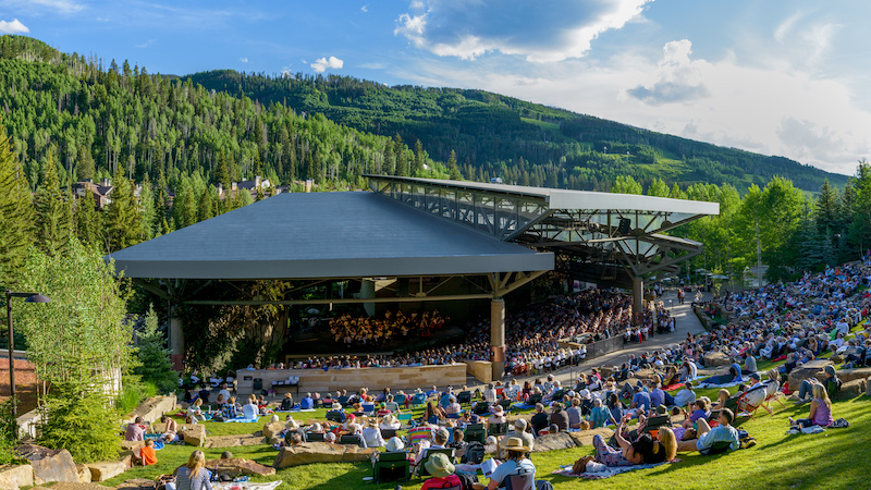 A Bravo! Vail orchestra concert at the scenic Gerald Ford Amphitheater with mountains in the background.