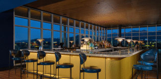 Rooftop bar with mid-century modern design aesthetic and floor to ceiling windows looking over the Air Force Academy.