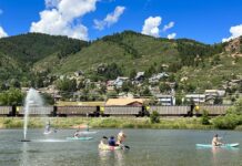 10 Water Activities to Beat the Summer Heat People paddle SUPs and an inflatable swan on Palmer Lake as a train passes by. Mountains line the horizon. It all makes Palmer Lake one of the best lakes in Colorado Springs.