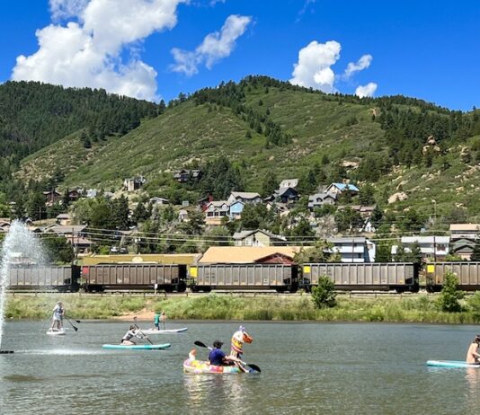 10 Water Activities to Beat the Summer Heat People paddle SUPs and an inflatable swan on Palmer Lake as a train passes by. Mountains line the horizon. It all makes Palmer Lake one of the best lakes in Colorado Springs.