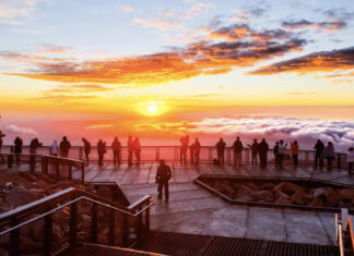 This Year You Can Watch Sunrise and Sunset on Pikes Peak A group of people stands on the observation deck and watches sunrise on Pikes Peak.