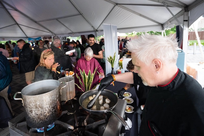 Chef Eric Brenner, owner of Red Gravy, cooks and serves in the VIP tent at Taste of Pikes Peak 2025. Photo by Allison Daniell, Stellar Propeller Studio.