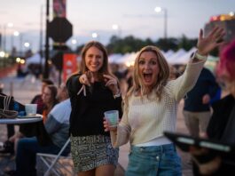Taste of Pikes Peak Serves Up a New Venue Two women wave with excitement at Taste of Pikes Peak, the Colorado Springs food festival of the year