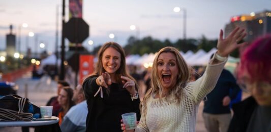 Taste of Pikes Peak Serves Up a New Venue Two women wave with excitement at Taste of Pikes Peak, the Colorado Springs food festival of the year