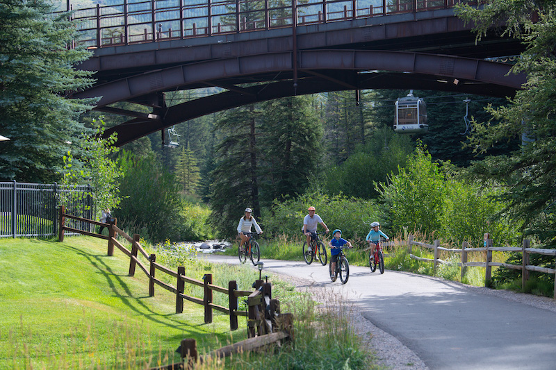 A family rides bikes along the Gore Creek Trail in Lionshead at Vail.