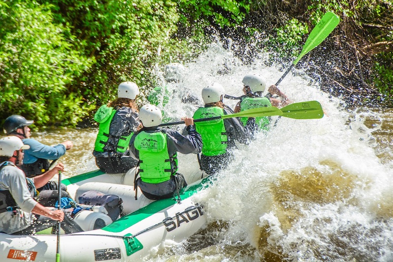 Rafters get splashed by a rapid with Sage Outdoor Adventures. 