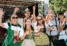 Where to Celebrate Oktoberfest 2026 in Colorado A group in lederhosen and dirndl cheer at Oktoberfest in Breckenridge Colorado