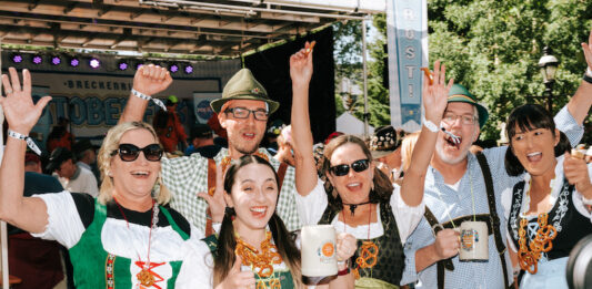 Where to Celebrate Oktoberfest 2026 in Colorado A group in lederhosen and dirndl cheer at Oktoberfest in Breckenridge Colorado
