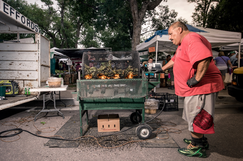 A large man roasting Pueblo chiles at the Pueblo Chile and Frijoles Festival in Pueblo, Colorado.