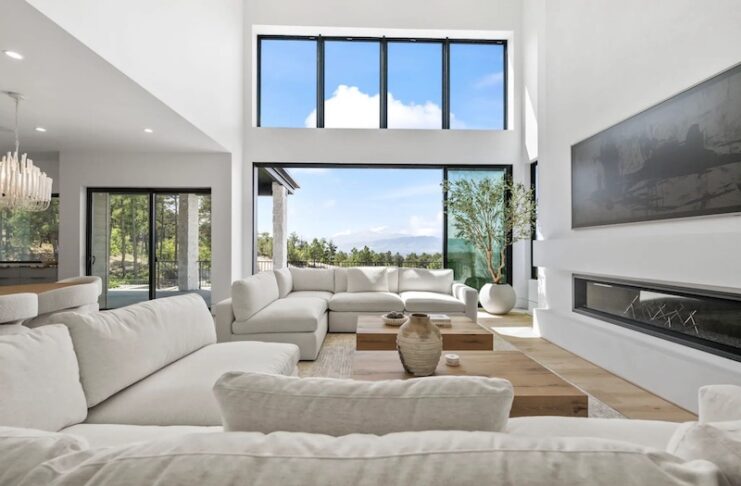 A wide living room with large windows showing a view of Pikes Peak in this 2025 Parade of Homes Colorado Springs home.