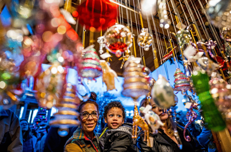 Woman and child enjoy festive holiday decorations during Christkindl Market.