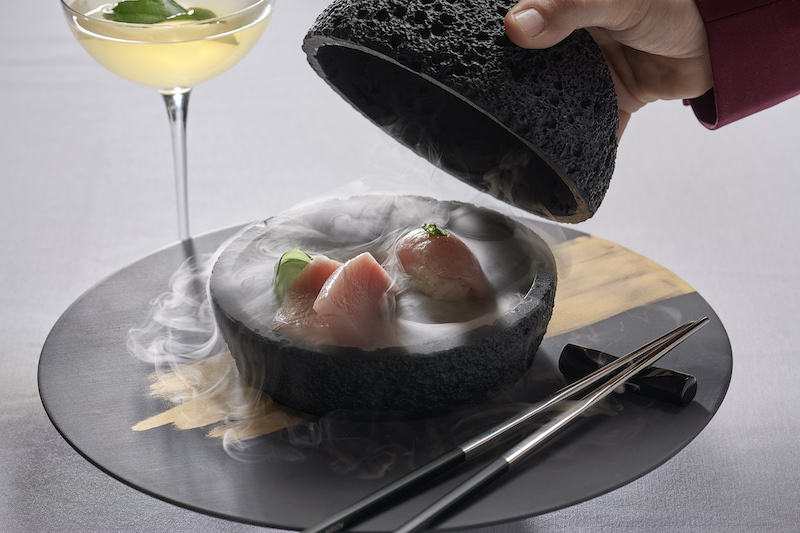 Smoke cascades as the lid is opened on a sushi dry ice volcano at Roth's Sea and Steak