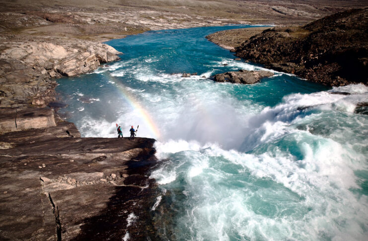 Kayakers stand in front of a raging waterfall in Baffin Vacation Love on Ice from the Banff Film Festival.