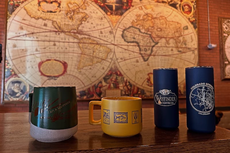 Coffee mugs and maps at Wayfinder Coffee Co., one of the People's Choice Awards Best Coffee Shops in Colorado Springs.