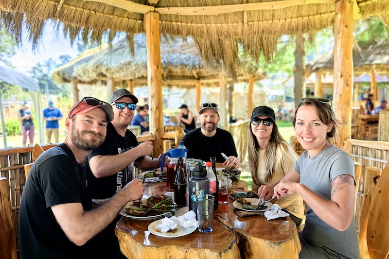 A group of travelers with Endure Adventures share a meal at the Iximche ruins in Guatemala.