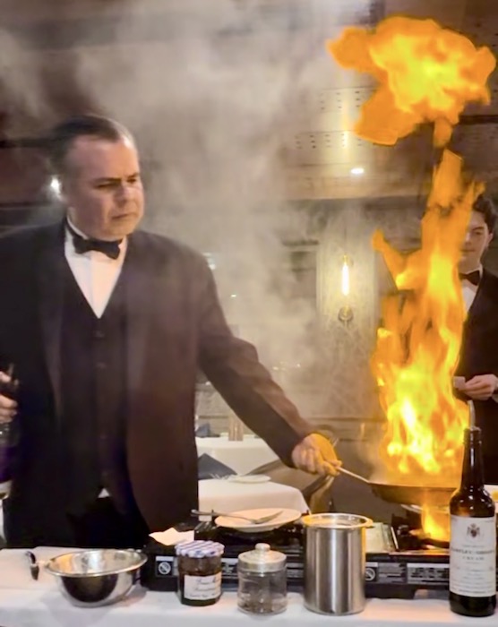 Chef server prepares steaks tableside as flames leap from the pan at The Peppertree, one of the best restaurants in Colorado Springs.