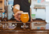 Goat Patch bartender serving a craft beer in Colorado Springs.