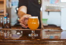 Goat Patch bartender serving a craft beer in Colorado Springs.