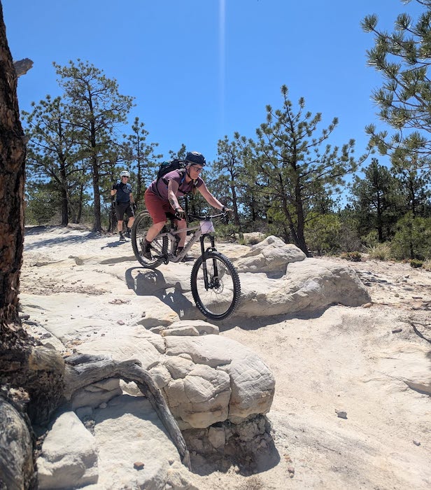 A woman rides a technical mountain biking trail in Colorado Springs.