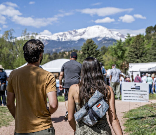 5 Best Things to Do in Colorado Springs This Weekend A couple walks toward the tents at the Garden of the Gods Art Festival with Pikes Peak in the background.
