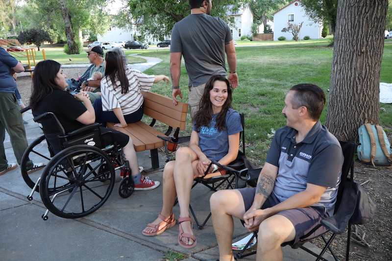 Neighbors in the Mid Shooks Run Park, including Elaine and Aaron Miner at right, gather for a 150 Tables taco party celebrating the summer solstice on June 21, 2026, in Colorado Springs.